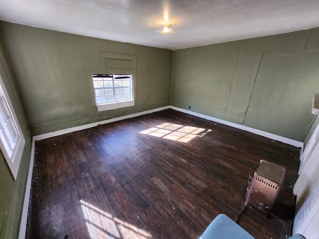 spare room with baseboards and wood-type flooring