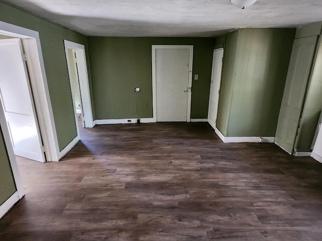 interior space featuring baseboards and dark wood-style flooring