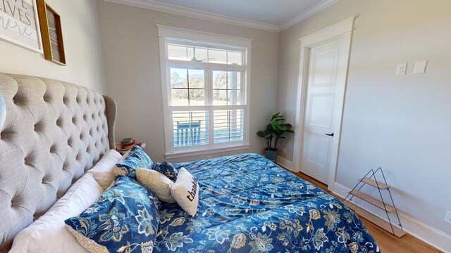 bedroom with ornamental molding and hardwood / wood-style floors