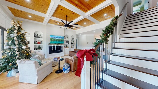 living room featuring light wood-type flooring, coffered ceiling, wood ceiling, and built in shelves