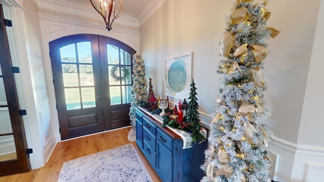 foyer featuring crown molding, light hardwood / wood-style flooring, and french doors