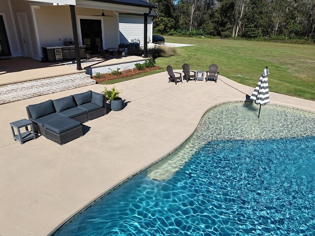 view of swimming pool featuring area for grilling, a yard, a patio, and ceiling fan