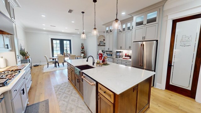 kitchen featuring white cabinetry, stainless steel appliances, sink, and a kitchen island with sink