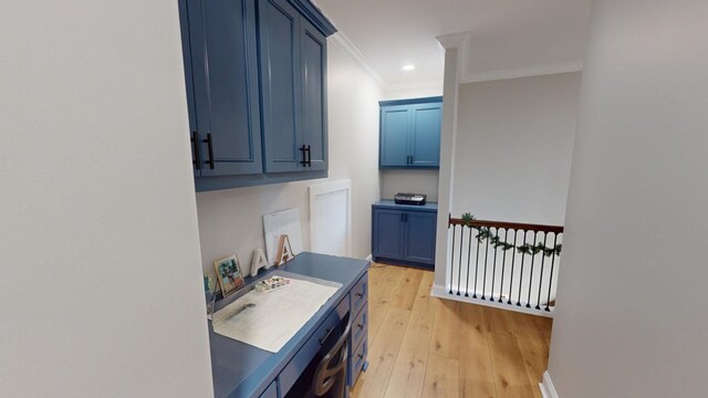 kitchen featuring ornamental molding, light hardwood / wood-style floors, and blue cabinets