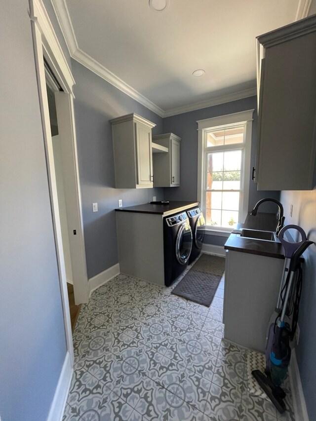 clothes washing area with separate washer and dryer, sink, cabinets, light tile patterned floors, and crown molding