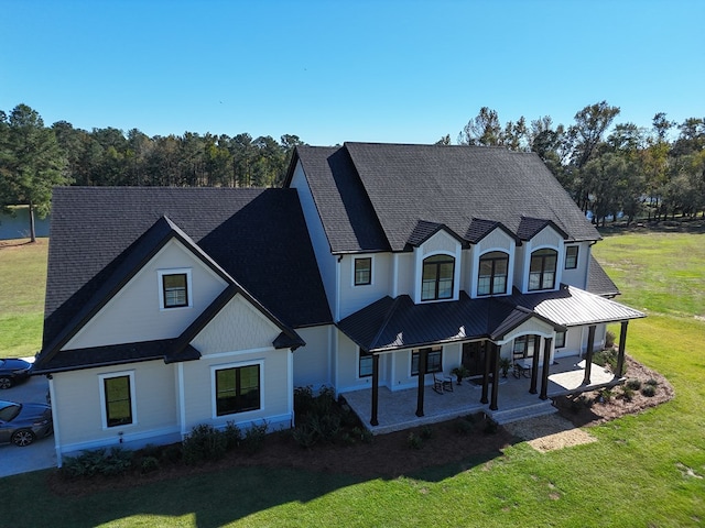 view of front of home with a front yard, a patio, and a porch