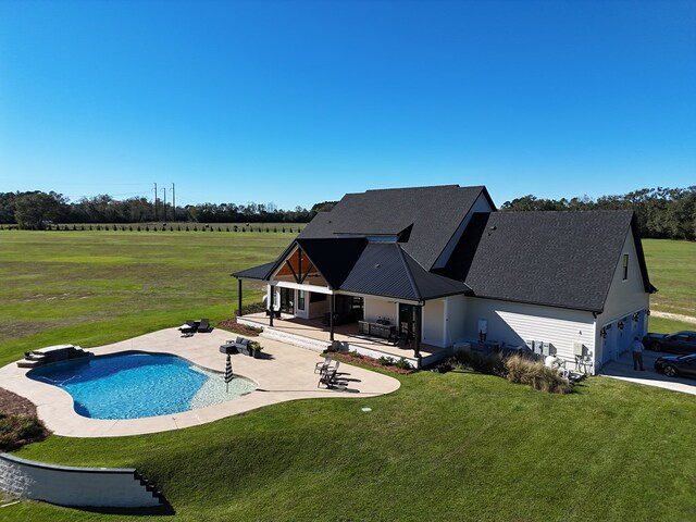 view of pool with a patio area and a lawn