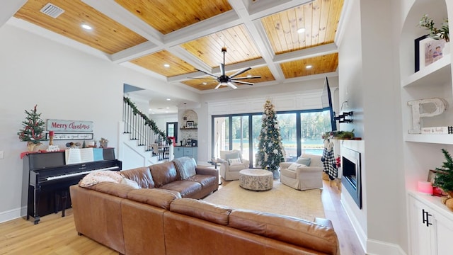 living room with wood ceiling, coffered ceiling, light hardwood / wood-style floors, and beam ceiling