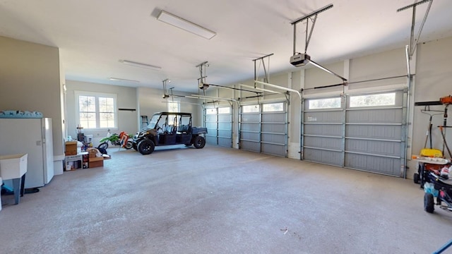 garage with a garage door opener and white fridge