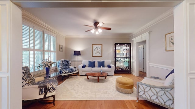 living room with ornamental molding, ceiling fan, and wood finished floors
