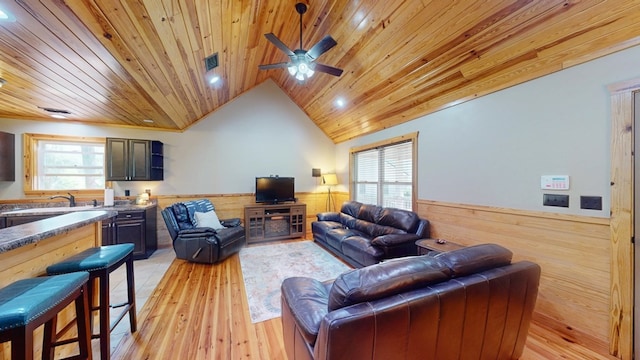 living room featuring wooden ceiling, wainscoting, vaulted ceiling, wooden walls, and light wood finished floors