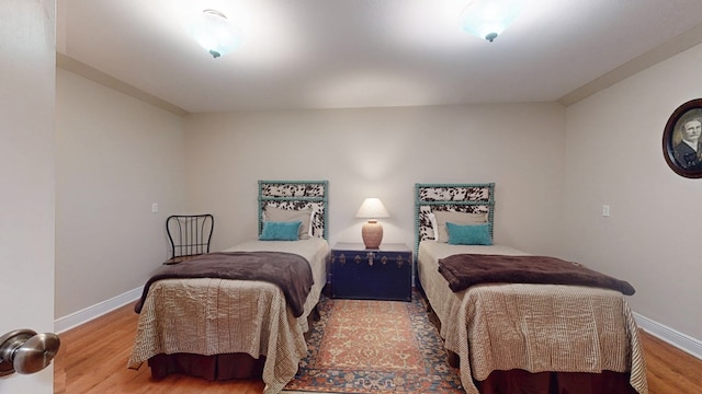 bedroom featuring baseboards and wood finished floors