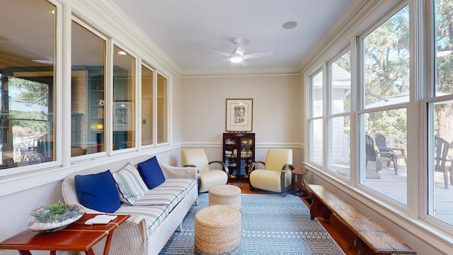 sunroom / solarium featuring healthy amount of natural light, wainscoting, and crown molding