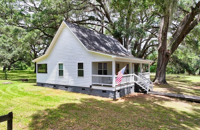 view of home's exterior featuring crawl space, covered porch, a yard, roof with shingles, and view of scattered trees