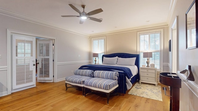 bedroom featuring light wood-type flooring, crown molding, and multiple windows