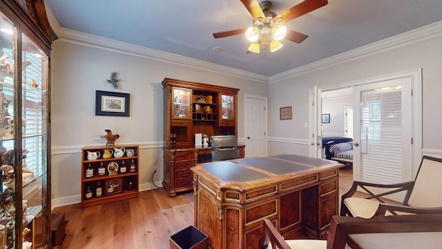 office space featuring plenty of natural light, a ceiling fan, light wood-style floors, and crown molding