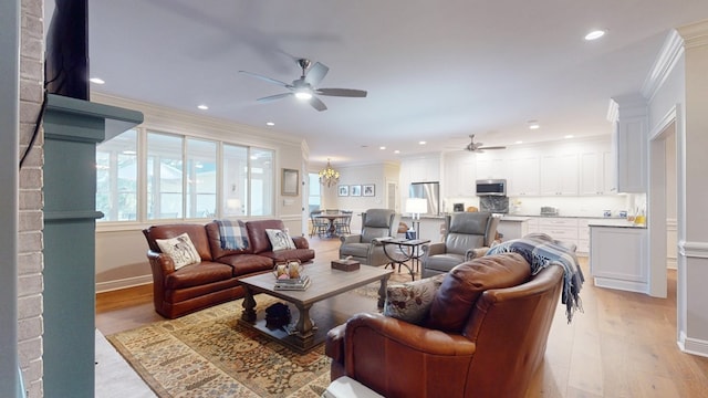 living area with a ceiling fan, ornamental molding, light wood-style flooring, recessed lighting, and a chandelier