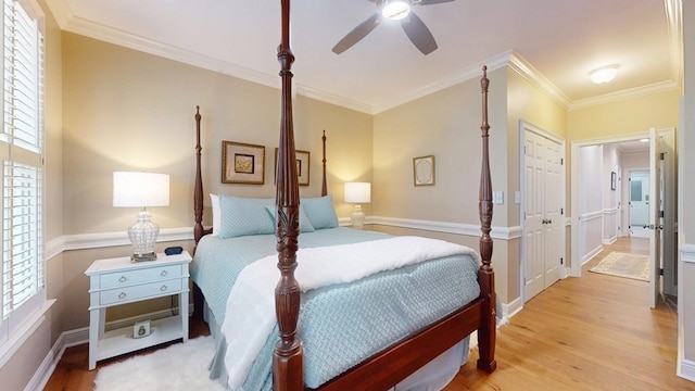 bedroom with wood finished floors, multiple windows, crown molding, and ceiling fan