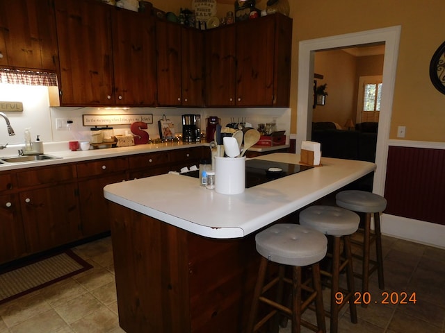 kitchen featuring a kitchen bar, a center island, and sink