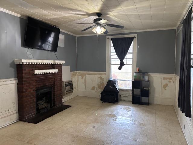 unfurnished living room with a wall mounted air conditioner, ceiling fan, ornamental molding, and a brick fireplace