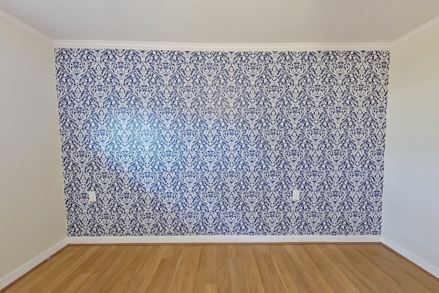 empty room featuring wood-type flooring and ornamental molding