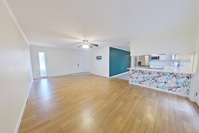 living room with sink, crown molding, light hardwood / wood-style flooring, and ceiling fan