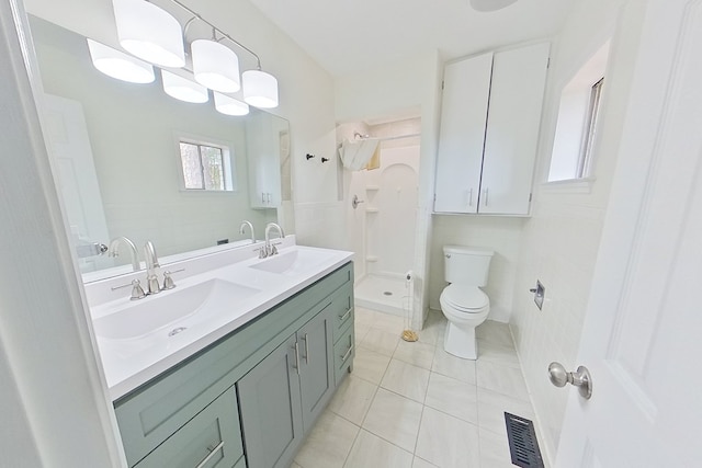 bathroom with tile patterned floors, toilet, a shower, tile walls, and vanity