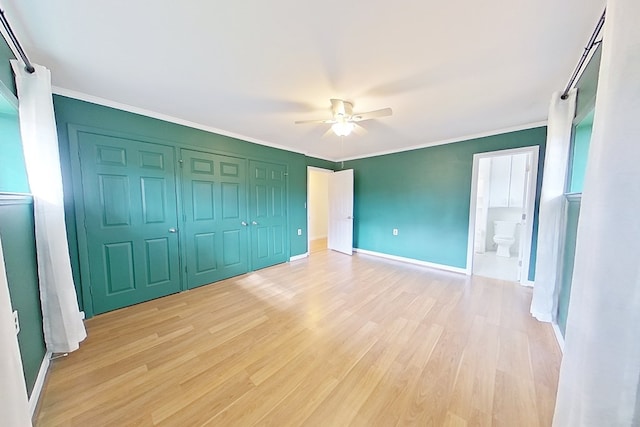 unfurnished bedroom with crown molding, ensuite bath, light wood-type flooring, a closet, and ceiling fan