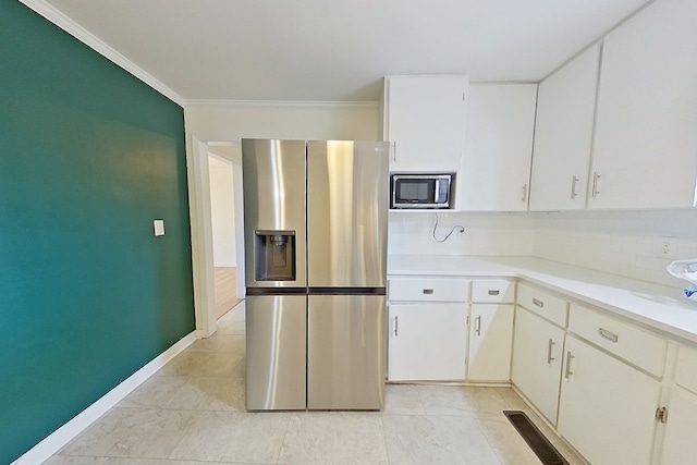 kitchen featuring white cabinetry, decorative backsplash, ornamental molding, light tile patterned floors, and stainless steel appliances