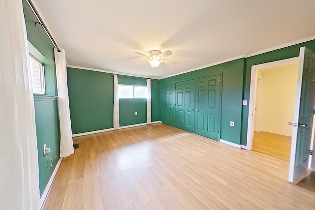 unfurnished bedroom featuring crown molding, a closet, ceiling fan, and light hardwood / wood-style flooring