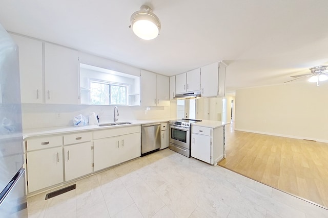 702 E Pinetree Blvd, Thomasville, GA 31792 - kitchen with appliances with stainless steel finishes, under cabinet range hood, light countertops, white cabinets, and ceiling fan