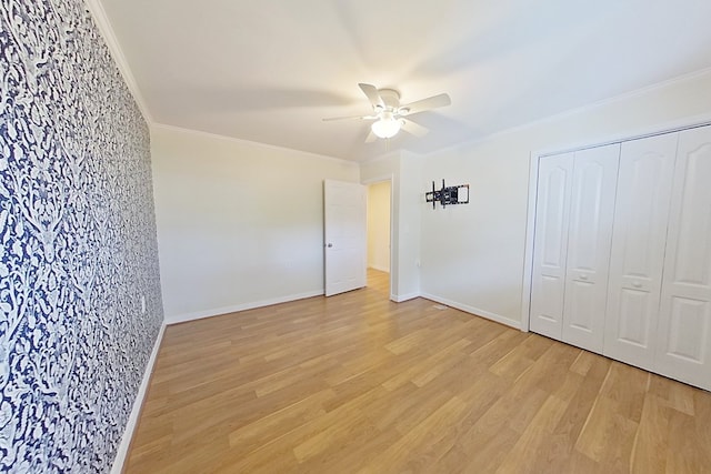 unfurnished bedroom with ceiling fan, a closet, ornamental molding, and light hardwood / wood-style flooring