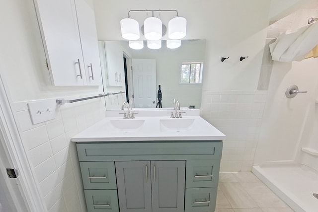 bathroom with walk in shower, vanity, tile patterned flooring, and tile walls