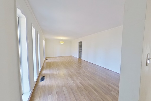 unfurnished room with crown molding and light hardwood / wood-style flooring