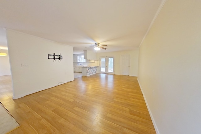 unfurnished living room featuring french doors, ceiling fan, crown molding, and light hardwood / wood-style flooring