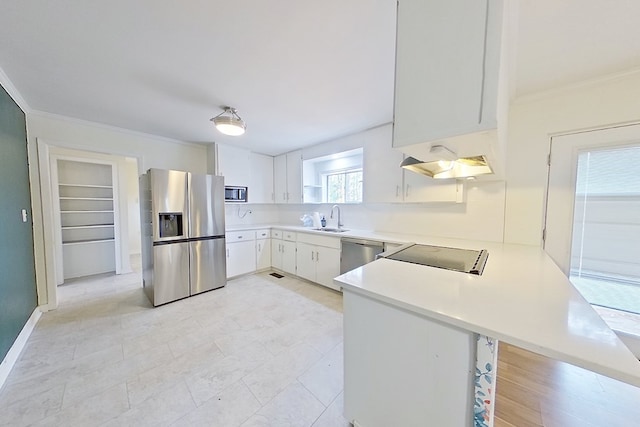 kitchen featuring sink, white cabinets, kitchen peninsula, stainless steel appliances, and crown molding