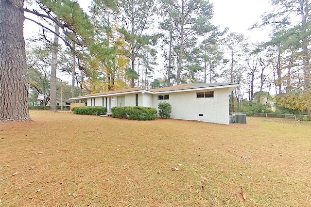 back of property with central AC and a lawn