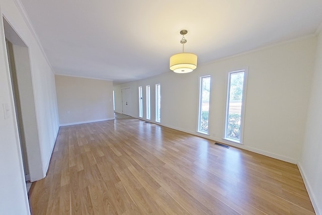 empty room featuring ornamental molding and light hardwood / wood-style flooring