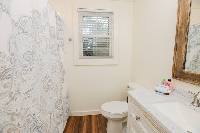 full bathroom featuring a shower with curtain, vanity, toilet, baseboards, and wood finished floors