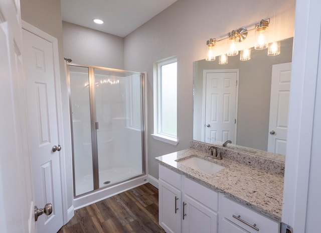 bathroom featuring vanity, wood-type flooring, and a shower with door