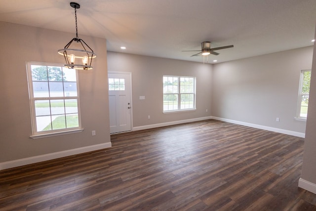 interior space with ceiling fan with notable chandelier and dark hardwood / wood-style flooring