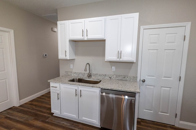 kitchen with dishwasher, sink, white cabinets, light stone counters, and dark wood-type flooring