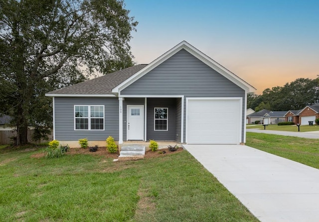 view of front of property with a garage and a lawn