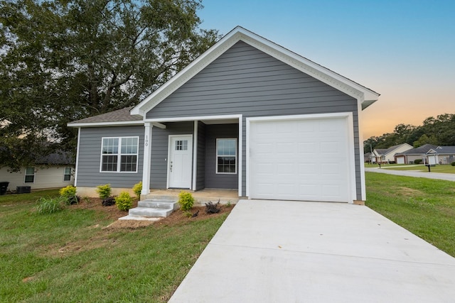 view of front of home with a garage and a yard