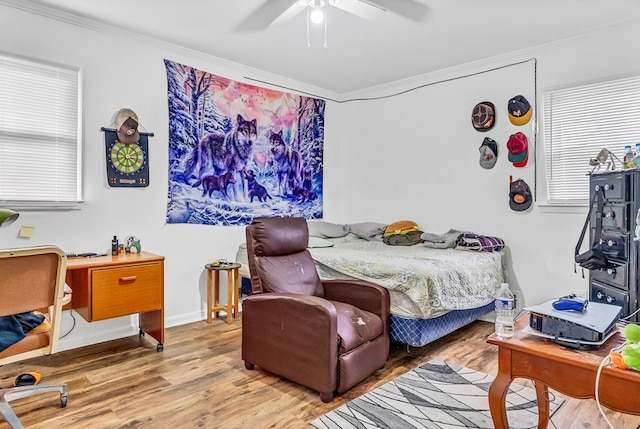 bedroom with crown molding, ceiling fan, and light hardwood / wood-style flooring