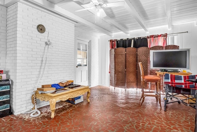 interior space with beam ceiling, ceiling fan, and brick wall