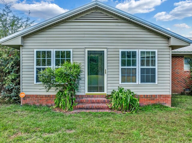 back of house featuring a lawn