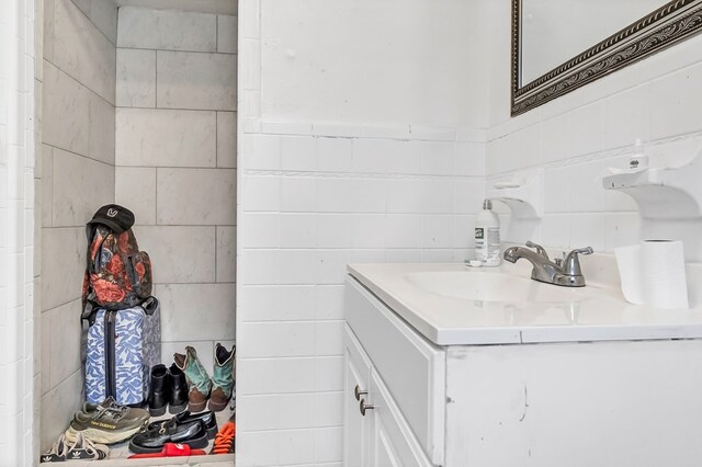 bathroom with vanity and tile walls