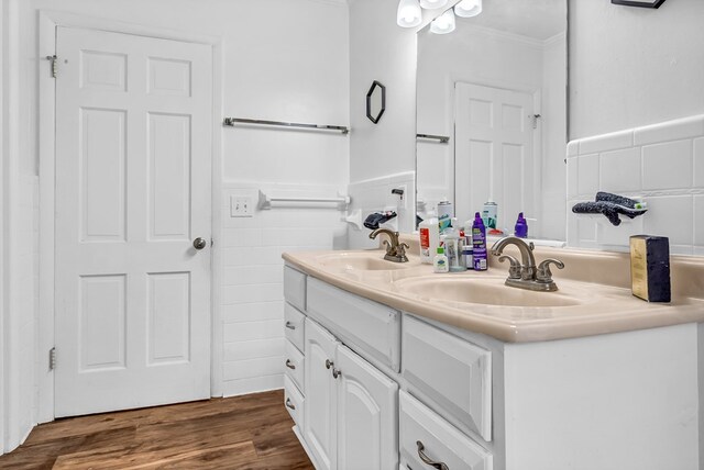 bathroom featuring tile walls, vanity, crown molding, and wood-type flooring