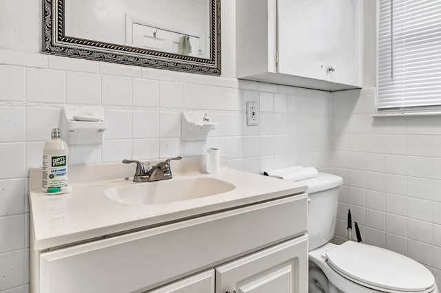 bathroom with vanity, tile walls, and toilet